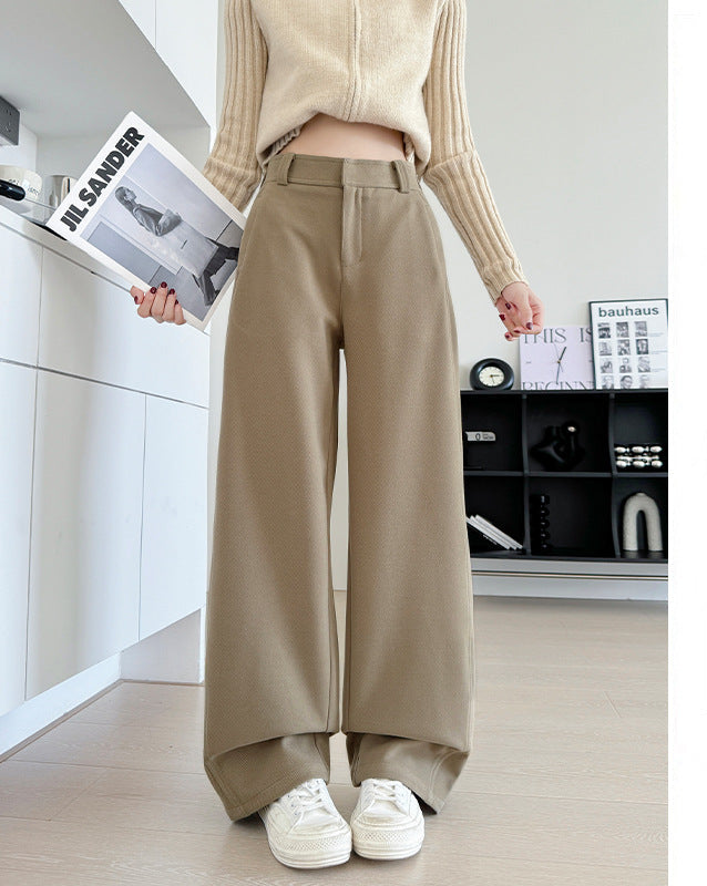 A person wearing beige wide-leg cropped pants and a cream knit sweater stands indoors holding a magazine. The image includes Chinese text on the right side describing the pants as加长款 (longer version) and noting a height recommendation of 164CM and above.