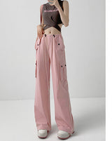 A model wears light pink wide-leg cargo pants with a drawstring waist and side pockets, paired with a dark crop top and white sneakers. The image includes a vertical text panel on the right in Chinese describing the color as light pink and noting a height recommendation of 164cm and above.