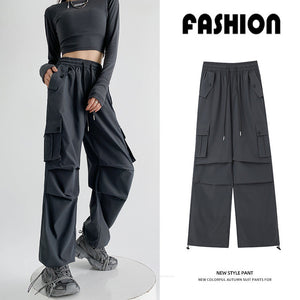 A model wears dark charcoal cargo-style pants with a cropped long-sleeve top and gray sneakers against a clean studio background. A smaller inset on the right shows the pants alone with Chinese product text above and below.