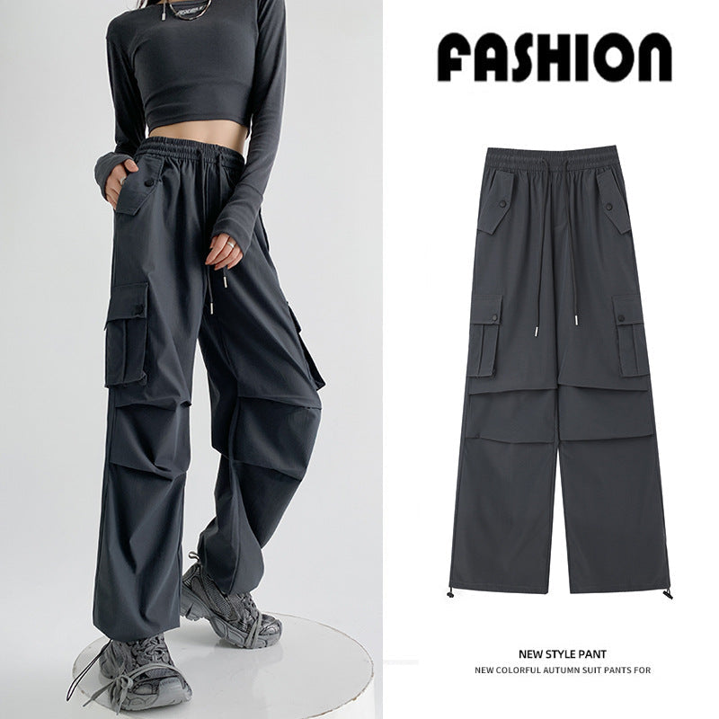 A model wears dark charcoal cargo-style pants with a cropped long-sleeve top and gray sneakers against a clean studio background. A smaller inset on the right shows the pants alone with Chinese product text above and below.